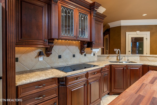 kitchen with wood counters, black electric stovetop, tasteful backsplash, ornamental molding, and sink