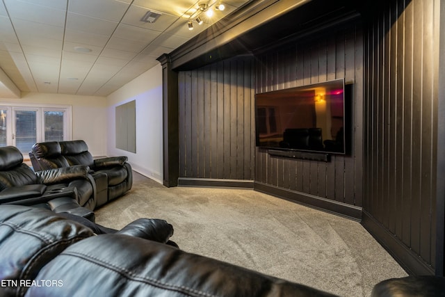 carpeted home theater room with wood walls