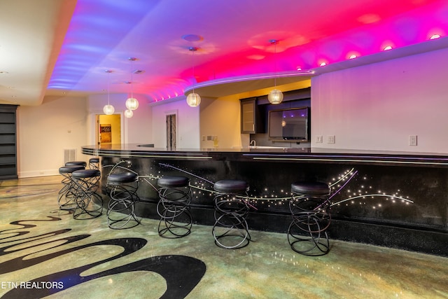 bar featuring concrete floors and hanging light fixtures