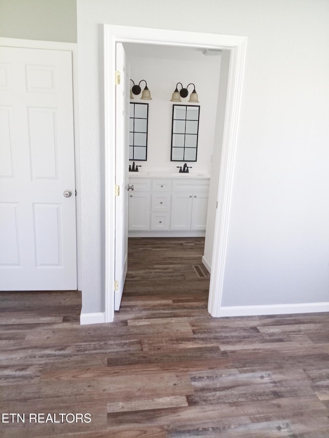 corridor with dark hardwood / wood-style floors and sink