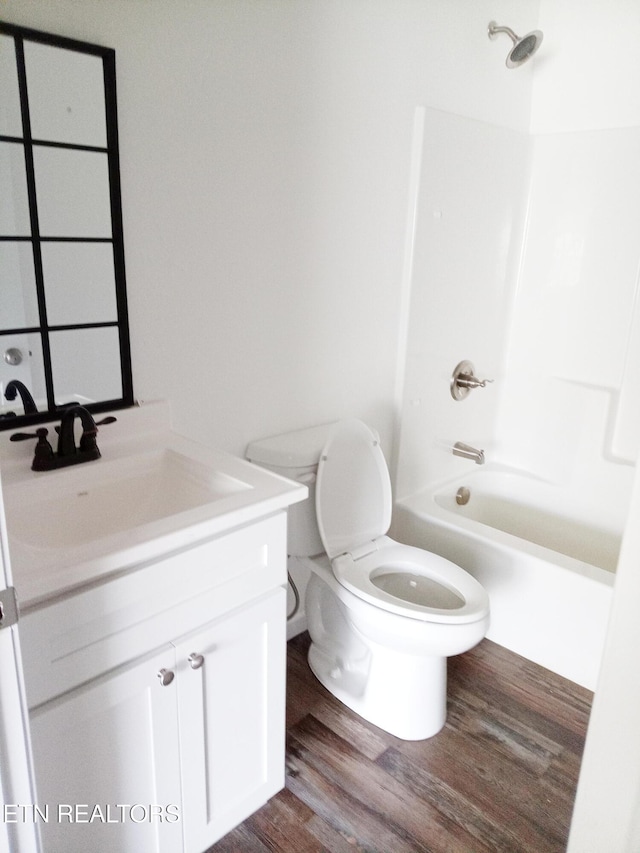 full bathroom featuring vanity, hardwood / wood-style flooring, toilet, and shower / bathtub combination