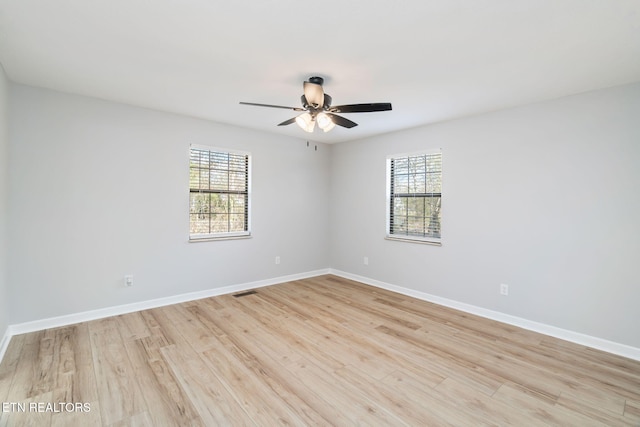 unfurnished room featuring a wealth of natural light, ceiling fan, and light hardwood / wood-style floors