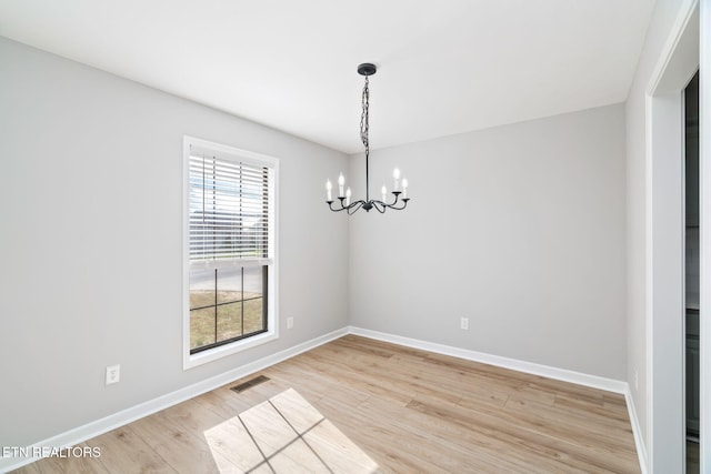 unfurnished dining area featuring wood-type flooring and a chandelier