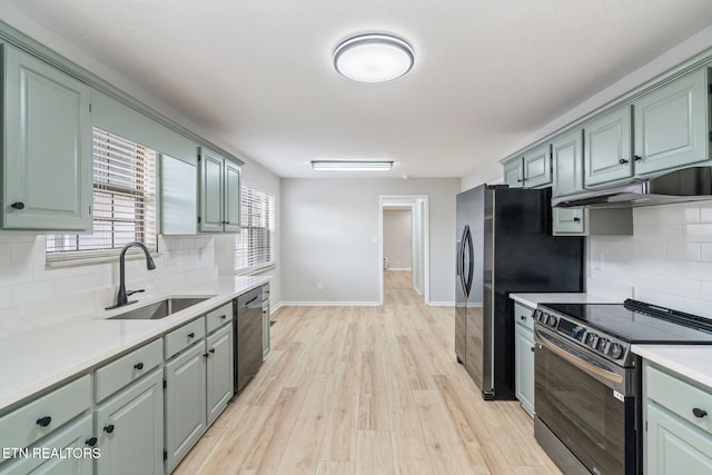 kitchen featuring tasteful backsplash, green cabinets, sink, and appliances with stainless steel finishes