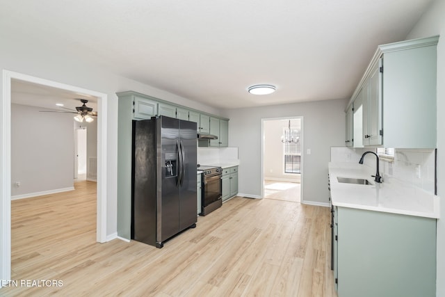 kitchen with range with electric cooktop, sink, decorative backsplash, stainless steel fridge, and light wood-type flooring