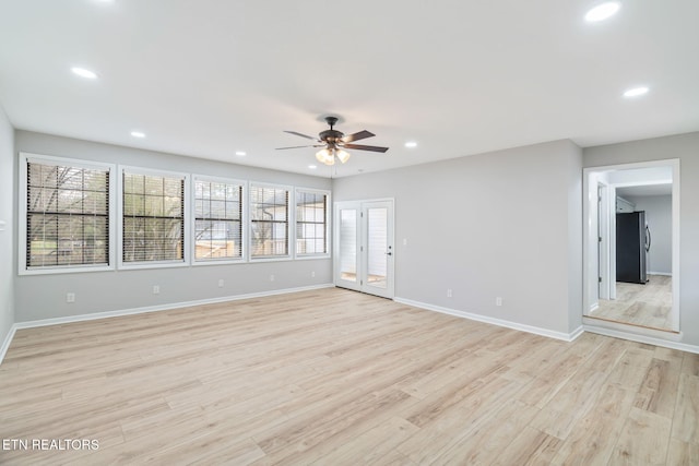 empty room with ceiling fan, french doors, and light hardwood / wood-style floors