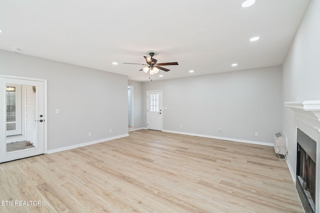 unfurnished living room featuring ceiling fan and light hardwood / wood-style floors