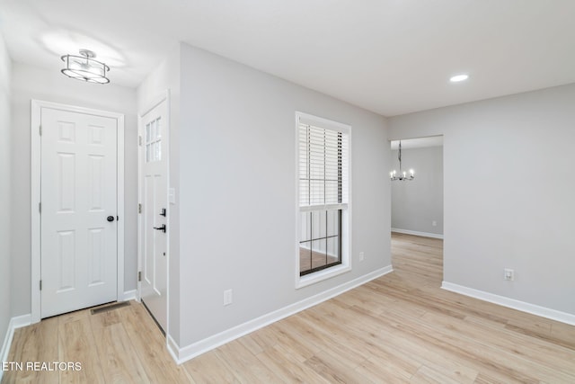 interior space with light hardwood / wood-style floors and a chandelier