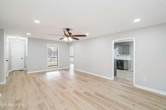 empty room with ceiling fan and light hardwood / wood-style floors