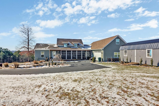 back of house with a sunroom and an outdoor structure