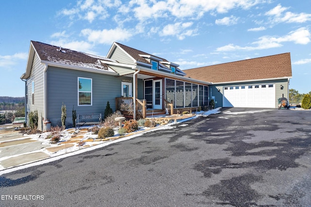 view of front facade with a garage and a sunroom