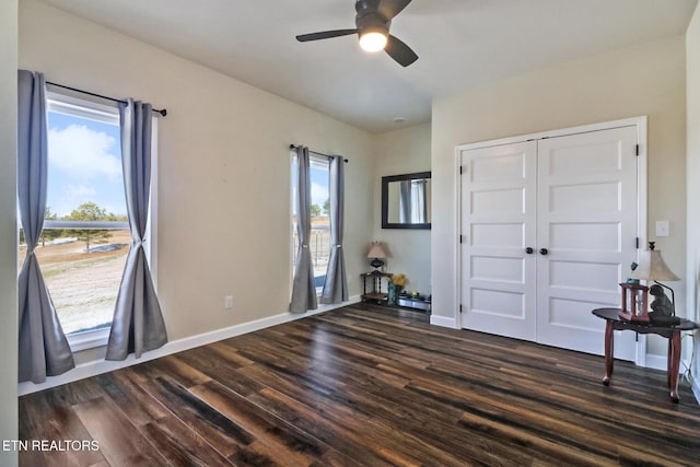 bedroom with multiple windows, ceiling fan, a closet, and dark hardwood / wood-style floors