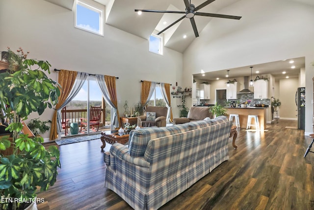 living room with a high ceiling, dark hardwood / wood-style floors, and ceiling fan