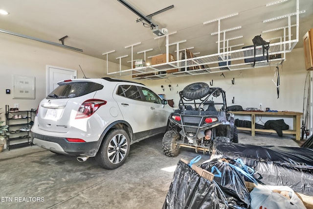 garage with a garage door opener and electric panel