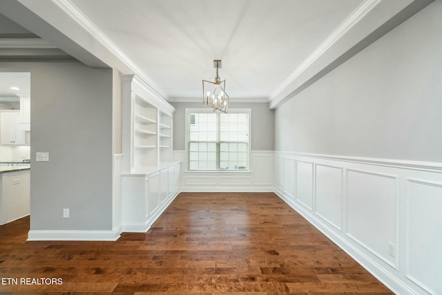 330 Kendall Hunt St, Knoxville, TN 37934 - unfurnished dining area featuring built in shelves, dark hardwood / wood-style flooring, ornamental molding, and a notable chandelier