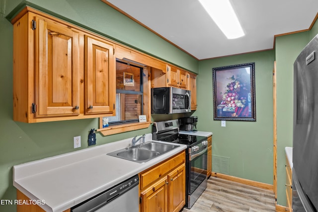 kitchen featuring sink, appliances with stainless steel finishes, and light hardwood / wood-style flooring