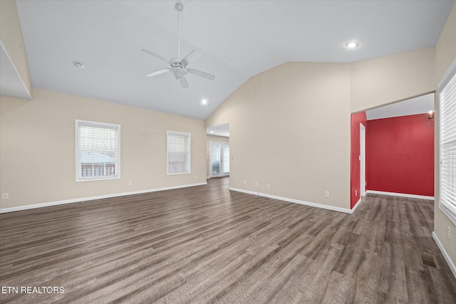 unfurnished living room with hardwood / wood-style floors, ceiling fan, a wealth of natural light, and vaulted ceiling