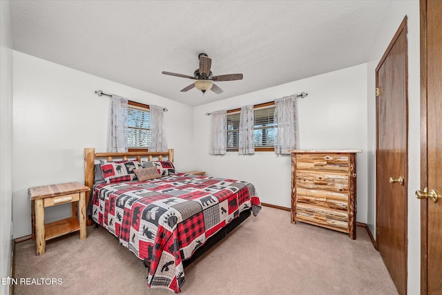 carpeted bedroom with ceiling fan and a textured ceiling