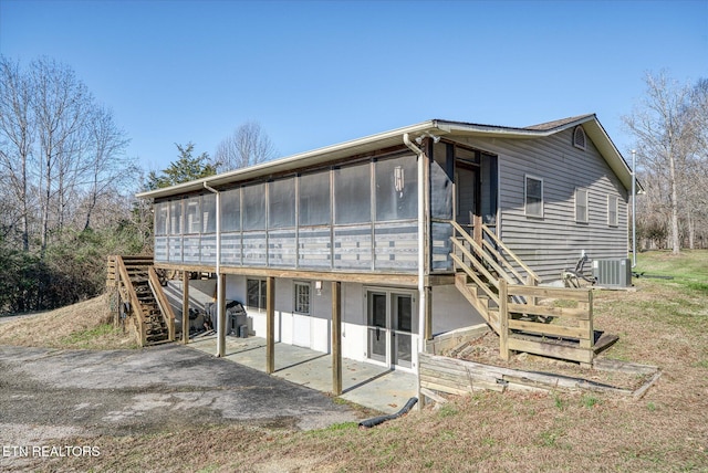 rear view of property with a patio, central AC unit, and a sunroom