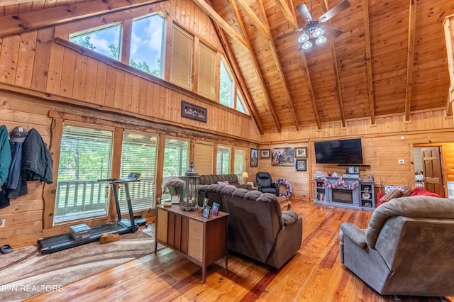 living room featuring beam ceiling, wooden walls, wooden ceiling, and hardwood / wood-style floors