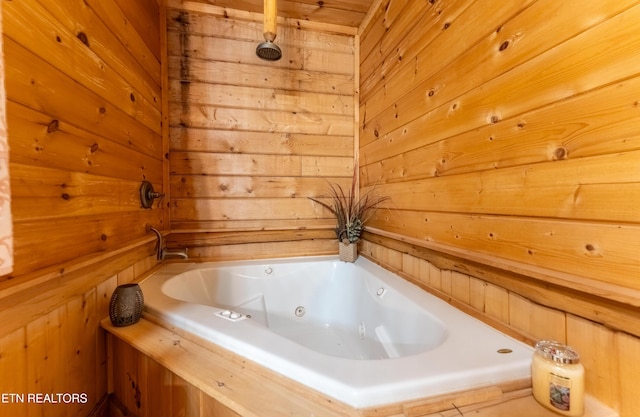 bathroom featuring a bath and wooden walls