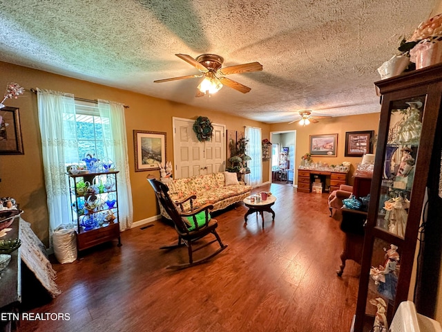 game room featuring ceiling fan, dark wood-type flooring, and a textured ceiling