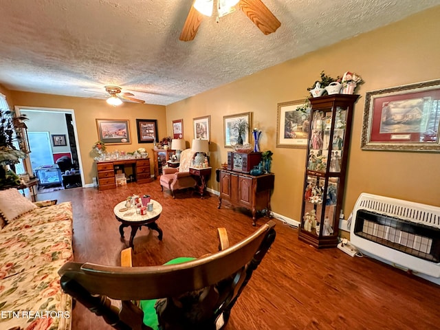 living room featuring heating unit, a textured ceiling, and hardwood / wood-style flooring