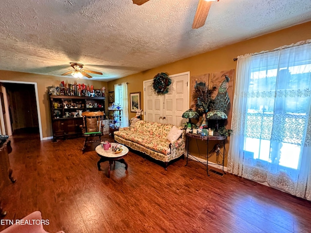 living room featuring a textured ceiling, dark hardwood / wood-style flooring, and ceiling fan