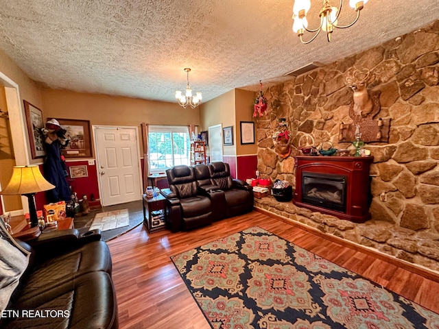 living room featuring a textured ceiling, hardwood / wood-style flooring, and a notable chandelier