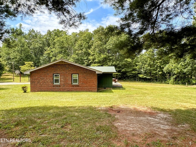 view of side of home with a yard