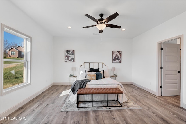 bedroom with light hardwood / wood-style floors and ceiling fan