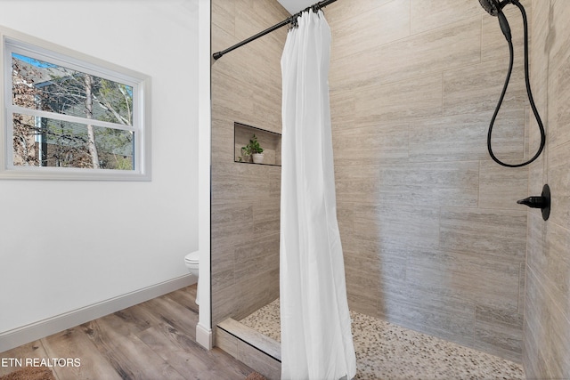 bathroom with a shower with curtain, hardwood / wood-style floors, and toilet