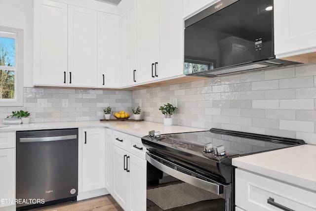 kitchen featuring backsplash, light stone counters, black appliances, white cabinets, and light hardwood / wood-style floors