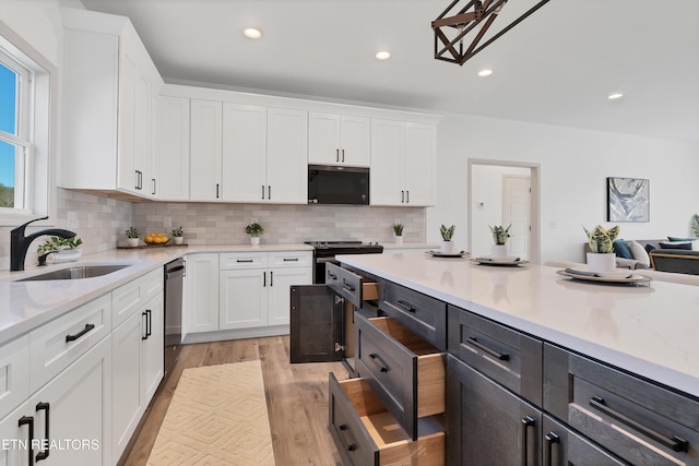 kitchen featuring black dishwasher, white cabinetry, stainless steel electric stove, and sink