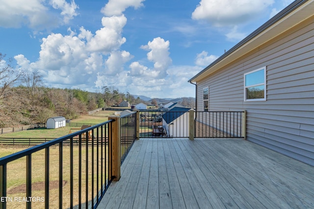 wooden deck featuring a mountain view, a shed, and a yard