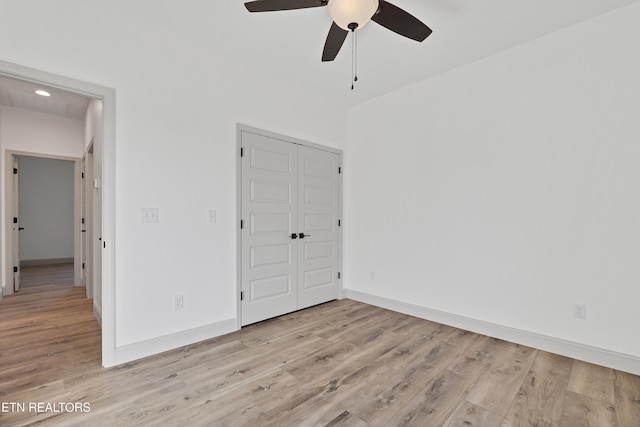 unfurnished bedroom featuring ceiling fan, light hardwood / wood-style flooring, and a closet