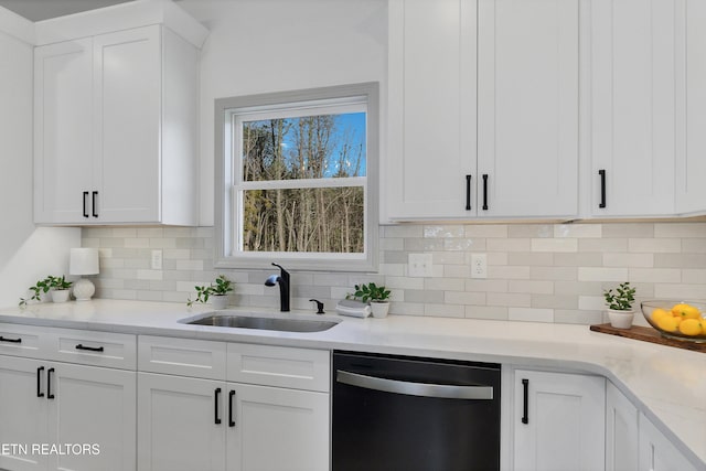 kitchen with light stone countertops, dishwasher, sink, decorative backsplash, and white cabinets