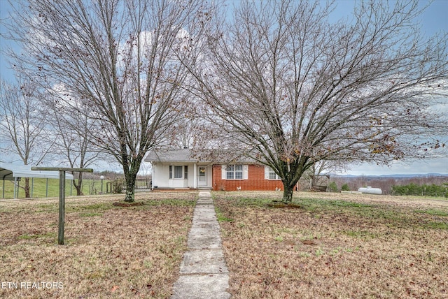 ranch-style house with a carport, covered porch, and a front yard