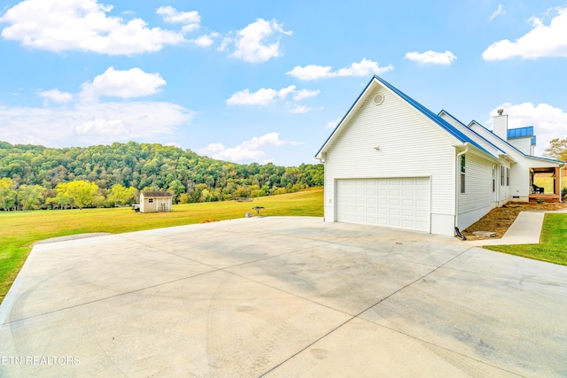 view of side of home with a storage unit, a garage, and a yard