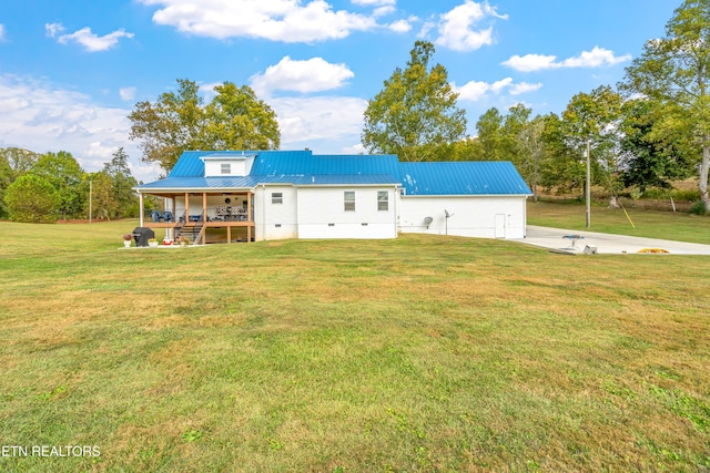 rear view of property with covered porch and a yard