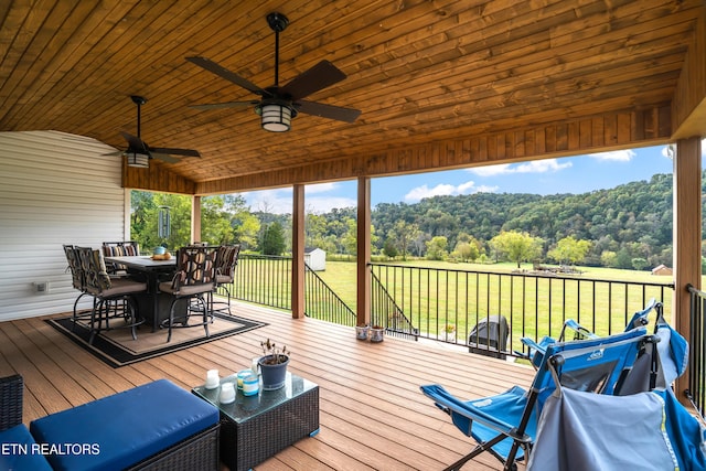 wooden terrace featuring a yard and ceiling fan