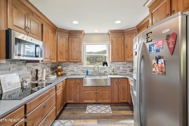 kitchen featuring dark hardwood / wood-style flooring, decorative backsplash, sink, and appliances with stainless steel finishes