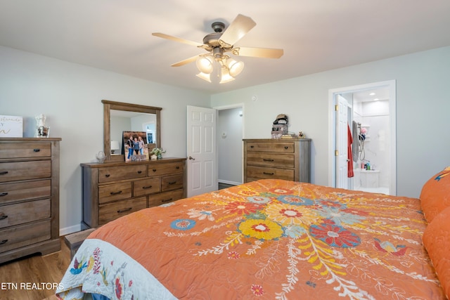 bedroom with ensuite bathroom, hardwood / wood-style floors, and ceiling fan