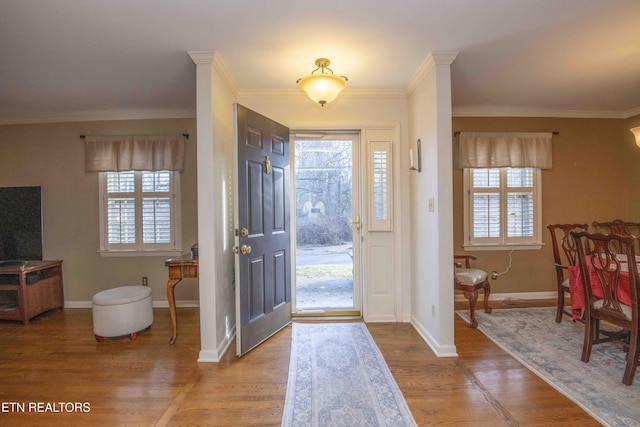 foyer featuring crown molding, plenty of natural light, and hardwood / wood-style floors