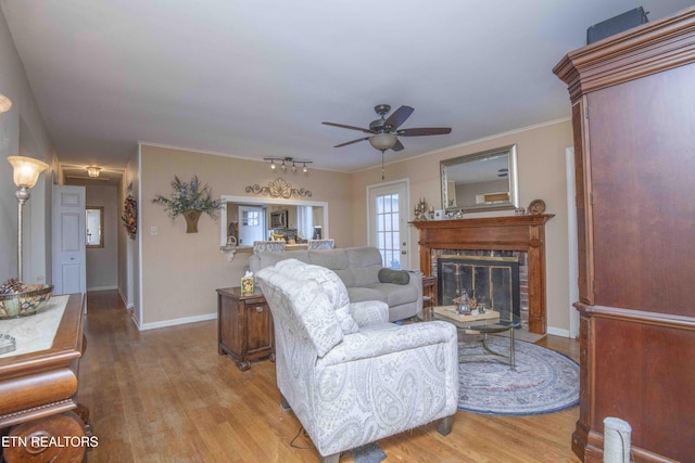 living room featuring ceiling fan, crown molding, and light hardwood / wood-style floors