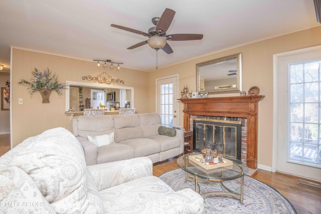 living room with ceiling fan, crown molding, and hardwood / wood-style flooring