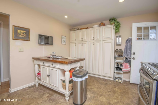 kitchen with stainless steel electric stove and wood counters