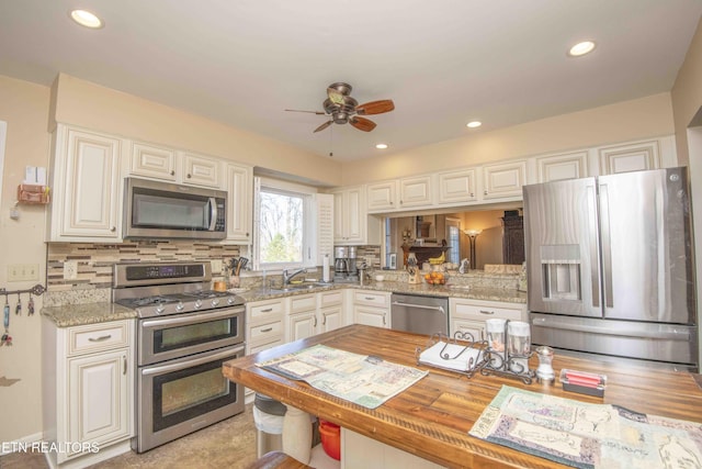 kitchen with decorative backsplash, sink, white cabinetry, and stainless steel appliances