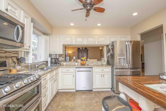 kitchen featuring wooden counters, white cabinets, sink, ceiling fan, and stainless steel appliances