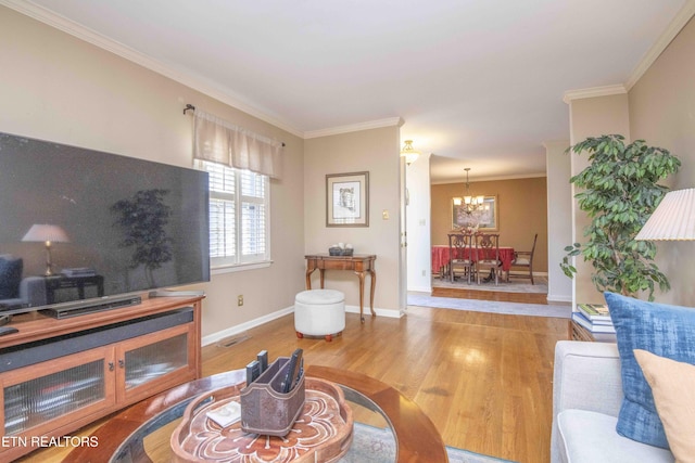 living room featuring light hardwood / wood-style flooring, a notable chandelier, and ornamental molding